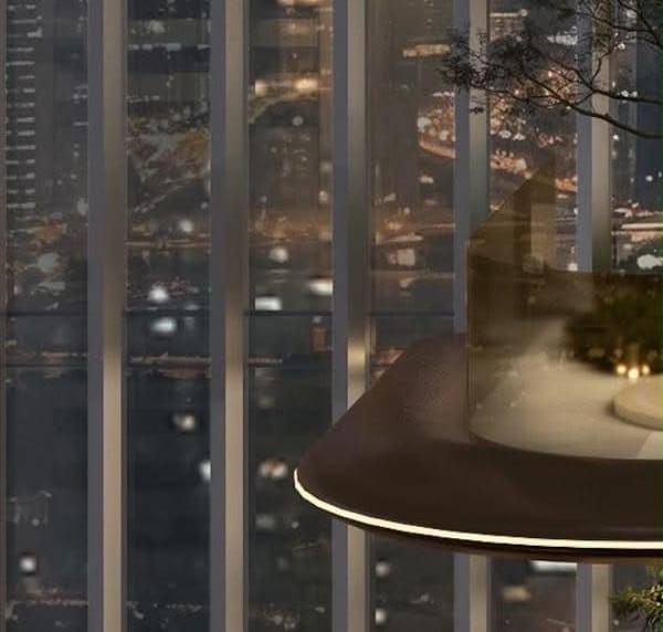 Night view through the vertical glass fins of the Ellington office tower in Business Bay, with a suspended landscaped terrace and the Dubai skyline beyond